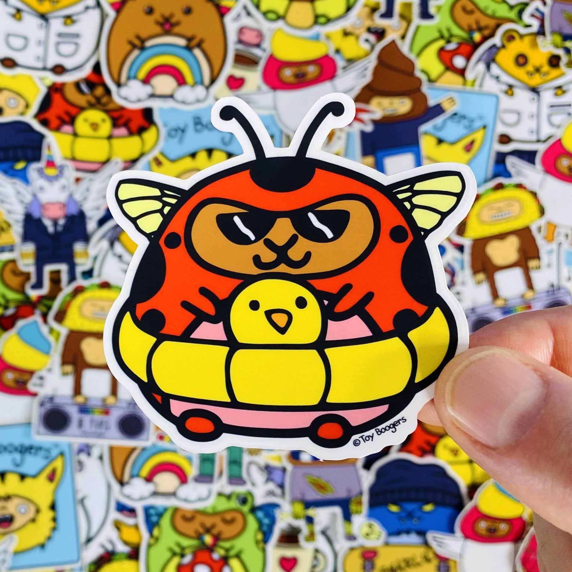 Cute sticker of a hamster in a ladybug costume inside a pool floatie and wearing sunglasses.