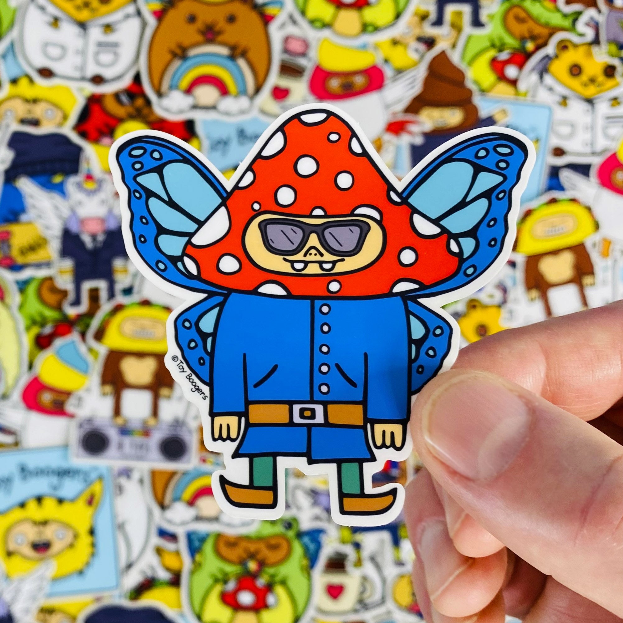 Funny sticker of a mushroom-Headed Gnome with butterfly wings and sunglasses.