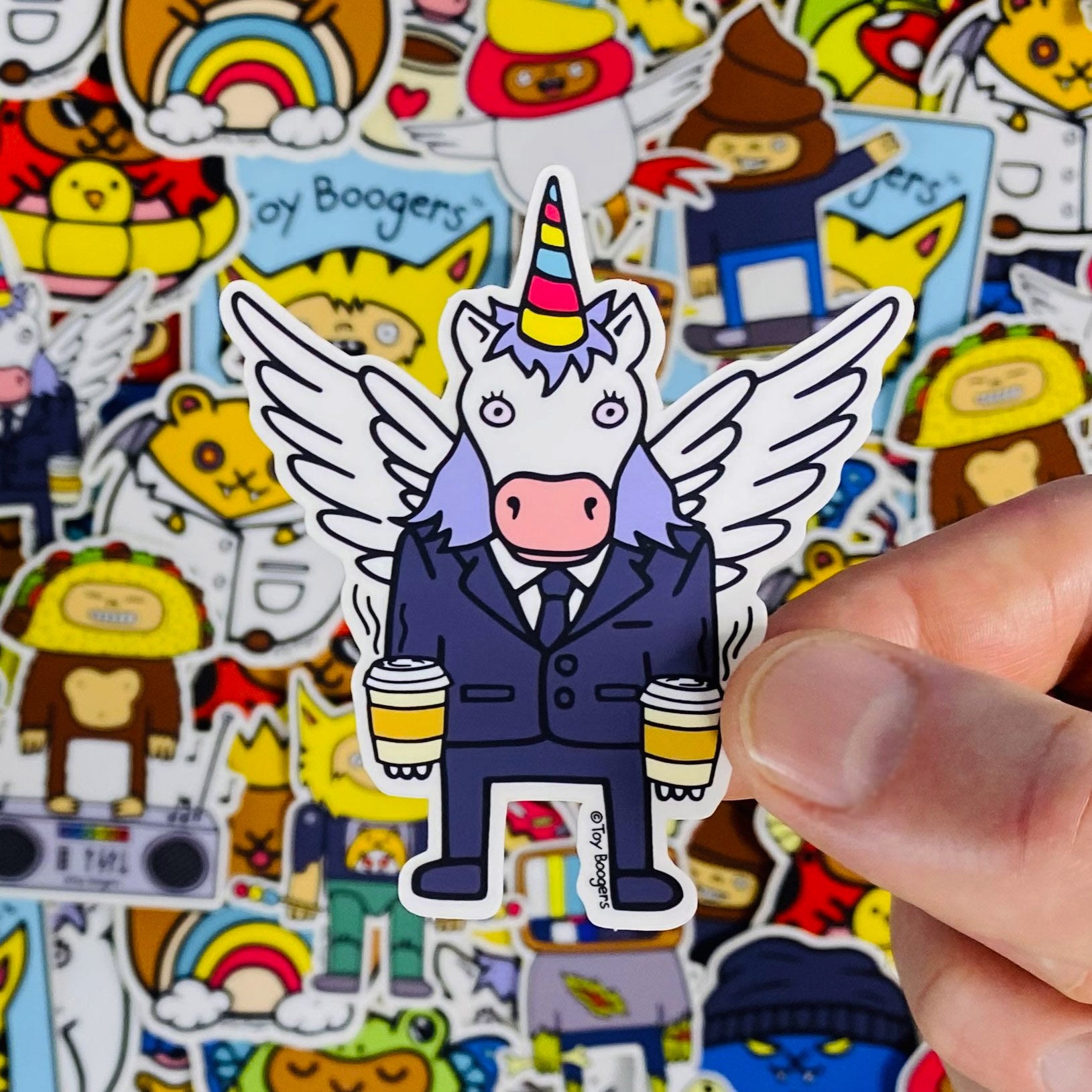 Funny sticker of a unicorn weaing a business suit holding two cups of coffee.